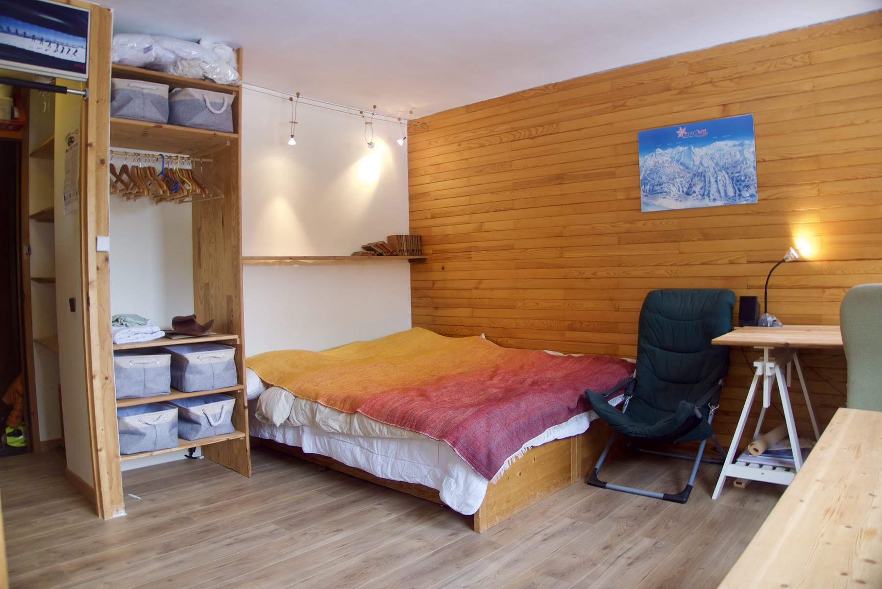 The main room in Appartement 824, with the double bed, storage and dining table