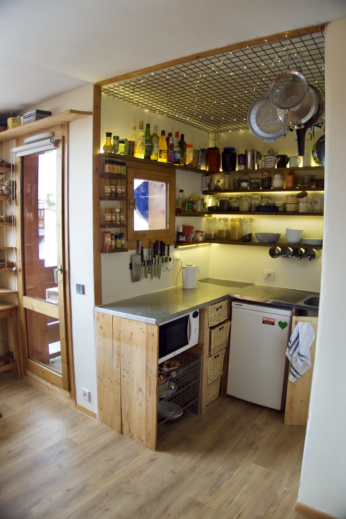The apartment kitchen with oven, fridge, sink and open storage